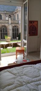 a bedroom with a bed and a view of a courtyard at LA TERRASSE DE NOTRE DAME in Le Havre