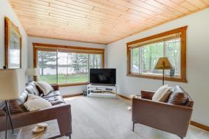 a living room with two couches and a flat screen tv at Minnesota Cabin with Deck and Private Beach in Merrifield