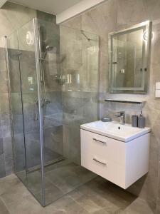 La salle de bains est pourvue d'une douche en verre et d'un lavabo. dans l'établissement Midom, à Małdyty