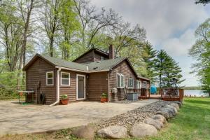 une petite maison avec une terrasse couverte et une allée. dans l'établissement Minnesota Cabin with Deck and Private Beach, à Merrifield