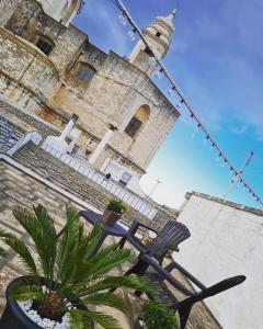 un bâtiment avec une chaise et une usine devant lui dans l'établissement La Dimora nel Borgo, à Locorotondo