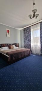 1 dormitorio con 1 cama y alfombra azul en Chernivtsi Apartments, en Chernivtsi