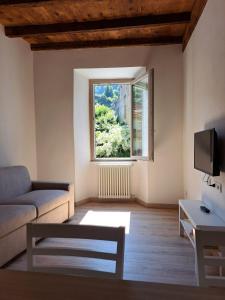 a living room with a couch and a window at CASA n 61 in Dervio