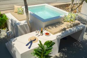 una piscina seduta accanto a un tavolo con di Loukas & Emma Houses a Perissa