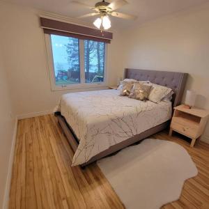 a bedroom with a large bed and a window at Lakefront Cottage in Sturgeon Falls