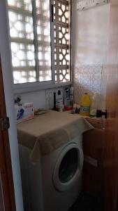 eine Waschmaschine im Bad mit einer Theke in der Unterkunft Apartamento pequeño frente al mar con piscina in Cullera