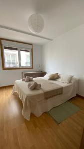 a white bedroom with a large bed in it at A Segunda Ronda in Melide