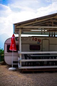 a red umbrella sitting next to a trailer at LE TERRAZZE SUL GARDA RELAIS in Biaza