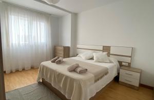 a bedroom with a bed with two towels on it at A Segunda Ronda in Melide