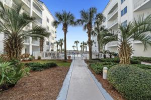einen Gehweg vor einem Gebäude mit Palmen in der Unterkunft Palm Beach Resort 15B in Gulf Shores