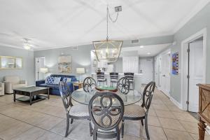 a dining room and living room with a table and chairs at Palm Beach Resort 15B in Gulf Shores