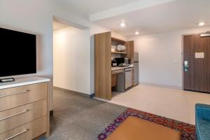 un ampio soggiorno con TV e cucina di Home2 Suites by Hilton Bangor a Bangor