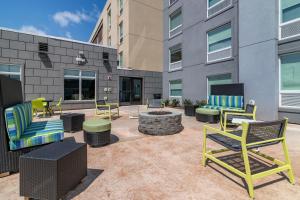 a patio with chairs and a fire pit in front of a building at Home2 Suites by Hilton Bangor in Bangor