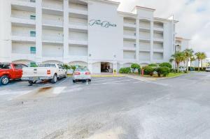 un parking en face d'un grand bâtiment dans l'établissement Palm Beach Resort 15B, à Gulf Shores