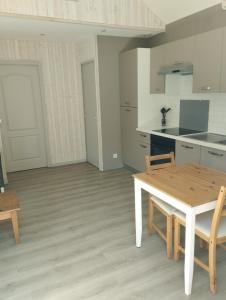 勒芒的住宿－Maisonnette en plein centre ville，白色的厨房配有木桌和椅子
