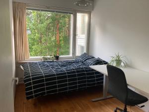 1 dormitorio con cama, escritorio y ventana en Tapiola Hill Apartment 2 bedroom and 1 living with private parking, en Espoo