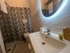 baño con lavabo y aseo y ventana en Spegni La Luce b&b, en Agropoli