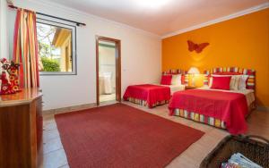 a bedroom with two beds and a red rug at Oceano Azul in Porto Santo