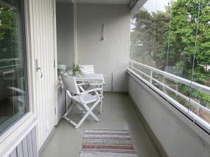 een veranda met een stoel, een tafel en een raam bij Tapiola Hill Apartment 2 bedroom and 1 living with private parking in Espoo
