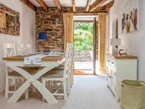 uma sala de jantar com uma mesa branca e cadeiras em Sandpiper Cottage em Salcombe