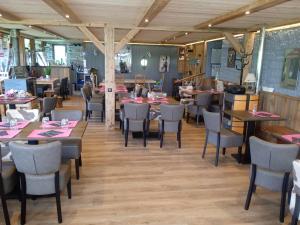 a restaurant with tables and chairs in a room at Auberge De La Grange spa & sauna in Plainfaing