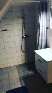 uma casa de banho com um chuveiro com um lavatório e uma cortina de chuveiro em Split em Veberöd
