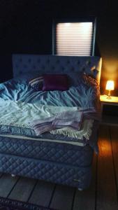 uma cama num quarto com um candeeiro e uma janela em Split em Veberöd