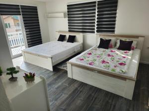 a bedroom with two beds and a balcony at Rooms Mery in Visoko
