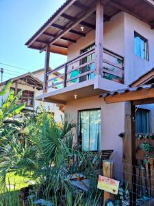 ein Haus mit einem Balkon mit Pflanzen davor in der Unterkunft Praia do Rosa loft com cozinha in Imbituba