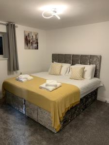 een slaapkamer met een groot bed met een gele deken erop bij 4 Bed- Trematon By Pureserviced in Plymouth