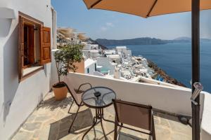 a balcony with chairs and a view of the ocean at Ostria Caldera Studios in Oia