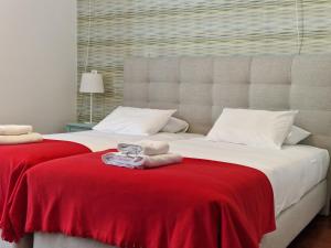 una camera con due letti con coperta rossa di Guest House do Largo a Faro