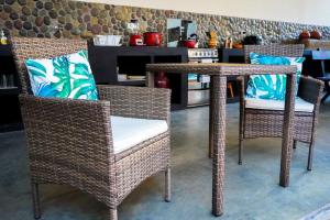 a wicker table and chairs with blue pillows on it at Casa Tesoro Selva in Tarapoto