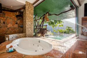 a large bath tub in a bathroom with a window at Villa Lala Boutique Hotel Adults Only in Puerto Vallarta