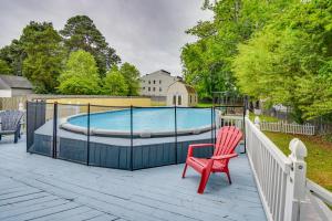 une chaise rouge assise sur une terrasse à côté d'une piscine dans l'établissement Norfolk Beach House Rental with Private Pool!, à Norfolk