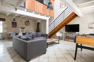 a living room with a couch and a tv at MACÉDOCY Maison de charme au cœur du Village in Sainte-Marie-de-Ré