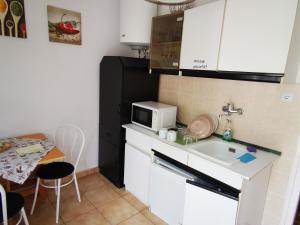 una pequeña cocina con fregadero y microondas en Paksy Apartman en Harkány