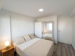 Un dormitorio blanco con una cama grande y una ventana en Sorolla Views Benidorm, en Benidorm