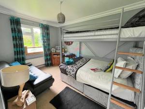 sypialnia z 2 łóżkami piętrowymi i krzesłem w obiekcie Redcastle Chateau by the Sea Sleeps 6!! w mieście Redcastle