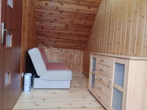 ein kleines Zimmer mit einem Stuhl und einer Kommode in der Unterkunft Olimp Resort in Sarbinowo