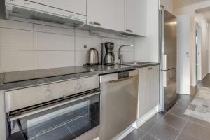 a kitchen with a stove and a dishwasher at Starvillas B 202 Sisältää loppusiivouksen in Kalajoki