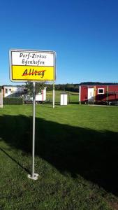 un panneau jaune assis au milieu d'un champ dans l'établissement Feriendörfle Fritz - Zirkuswagen (rot), à Ettenbeuren