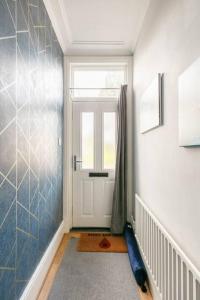 a hallway with a white door and a window at Atrium House in Hazel Grove