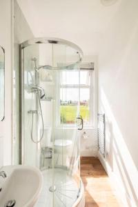 a bathroom with a glass shower and a sink at Atrium House in Hazel Grove