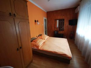 1 dormitorio con 1 cama con paredes de color naranja en Paksy Apartman en Harkány