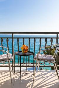 a table and chairs on a balcony with the ocean at Solar Beach Inn in Split
