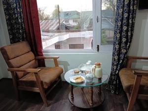 a living room with a table and a chair and a window at Himalayan Haven in Srinagar