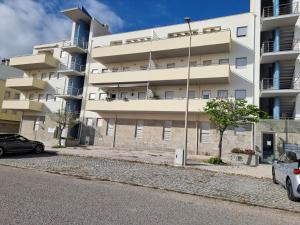 an apartment building with cars parked in front of it at Casa Pedra da Nau- 2 bedroom APT @Figueira da Foz in Buarcos