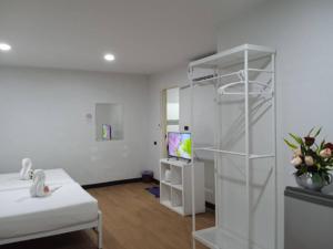 Zimmer mit einem Bett und einem Zimmer mit einem TV in der Unterkunft NK Guesthouse 1 in Klong Toi