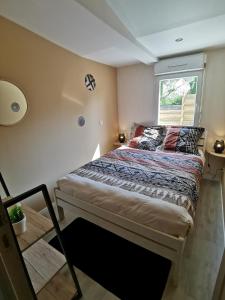 Dormitorio pequeño con cama y ventana en La chaumière en Longues-sur-Mer